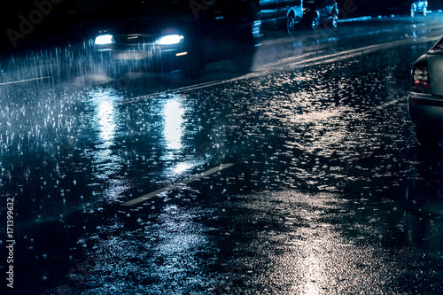 cars driving on street during heavy rain at night  blurred view