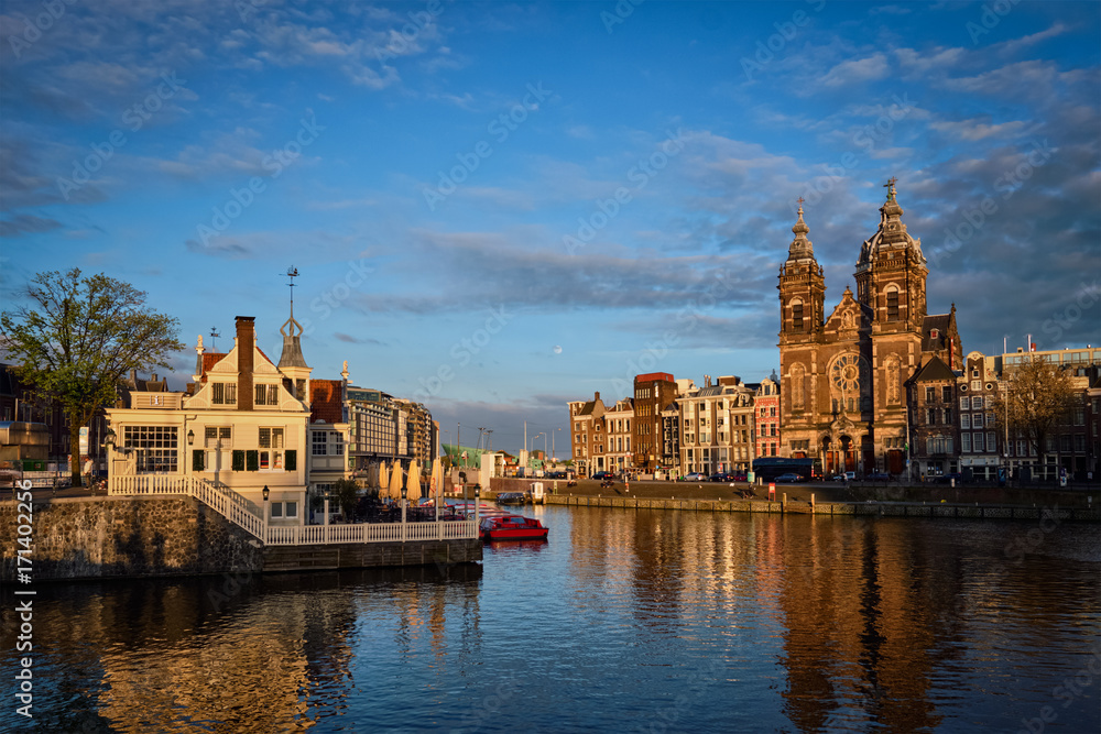 Fototapeta premium Amsterdam canal and Church of Saint Nicholas on sunset
