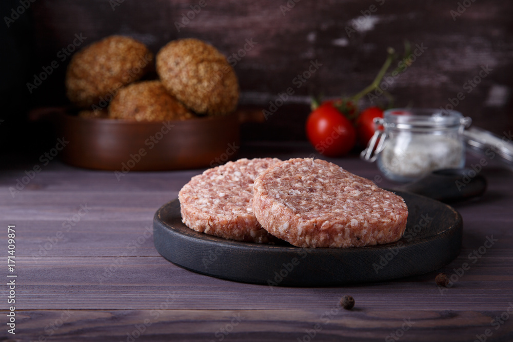 Raw minced beef meat burger cutlets on dark wooden background. Raw minced beef meat burger cutlets on dark wooden background.