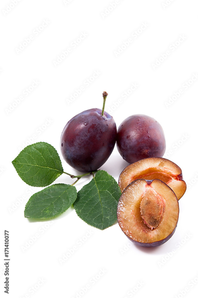 Fototapeta premium Group of whole and half of ripe plums with leaf isolated on a white background..