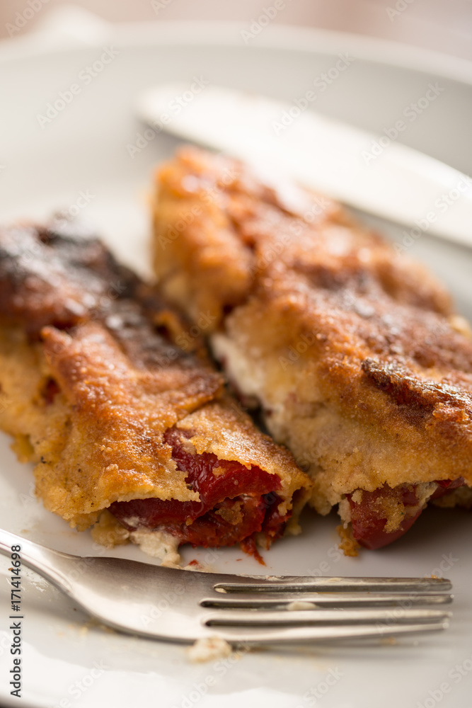 Grilled and fried in eggs paprika with knife and fork on the plate