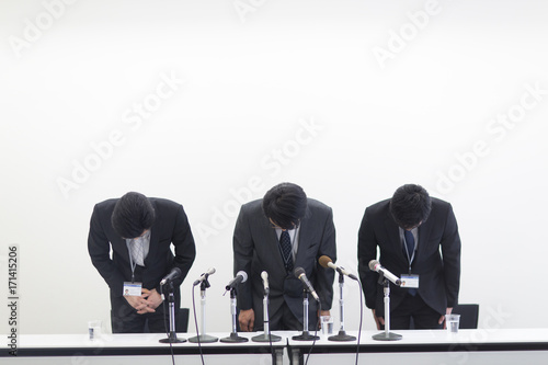 Three businessmen bowing photo