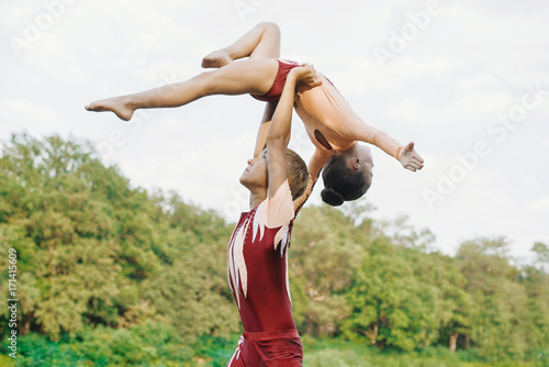 Boy and girl kids gymnasts performing paried exercices in park. Healthy lifestyles concept. photo