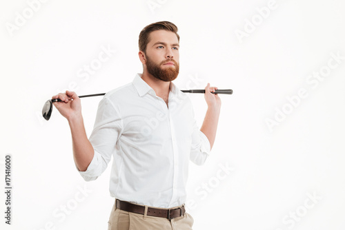 Young bearded man standing over white wall photo