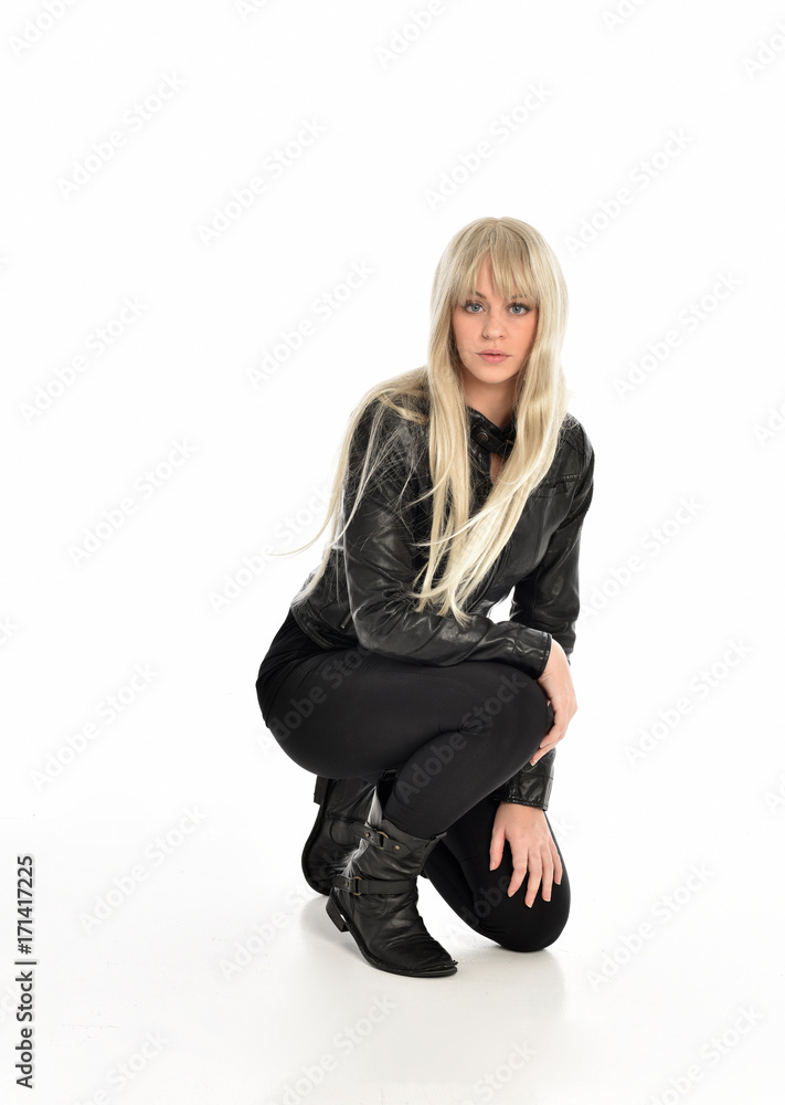 full length portrait of a blonde girl wearing black leather pose, crouching pose on white background. full length portrait of a blonde girl wearing black leather pose, crouching pose on white background.