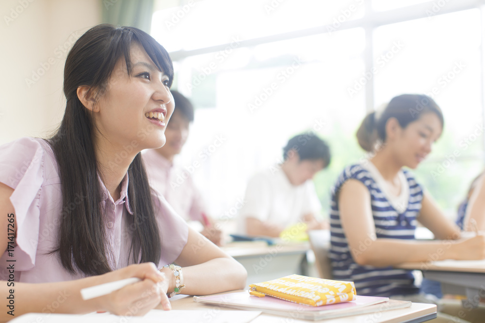 Female College Student in Classroom Holding Pen Female College Student in Classroom Holding Pen