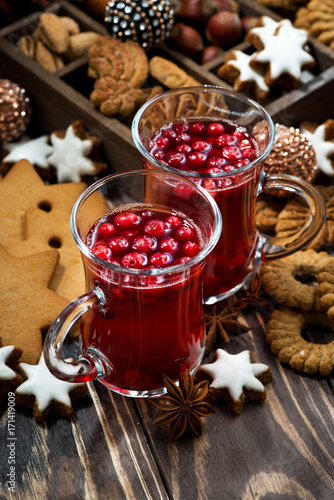 Christmas drink hot cranberry tea and cookies on dark background, vertical