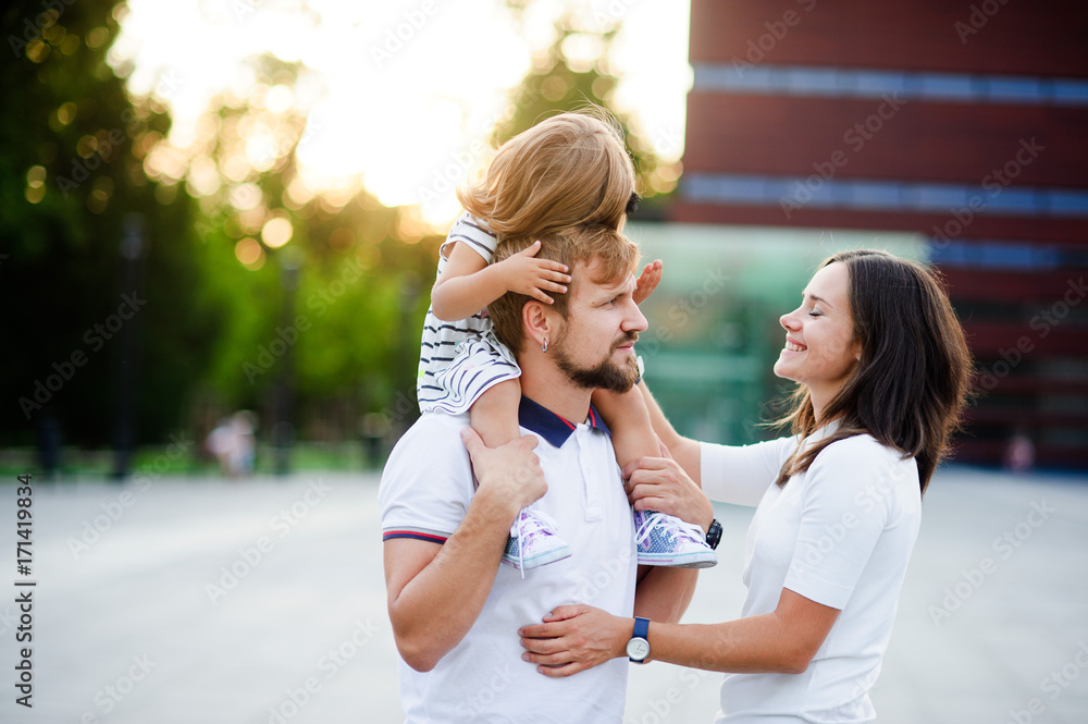Cute young family on a summer day in the city square. Cute young family on a summer day in the city square.