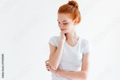 Pretty ginger woman in t-shirt looking down