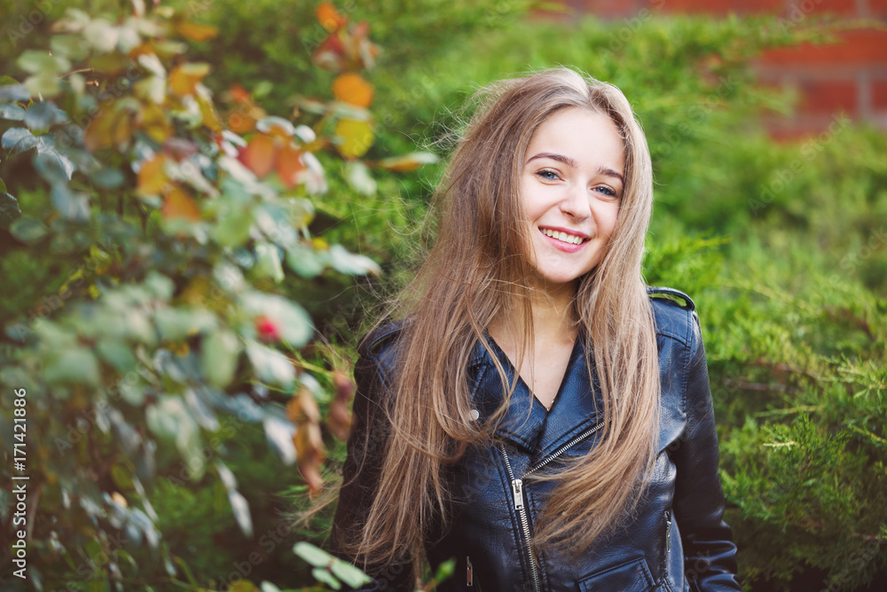 Portrait of the cheerful young girl in a park Portrait of the cheerful young girl in a park