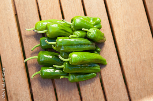 a pile of Pimientos de Padron on a wooden Table