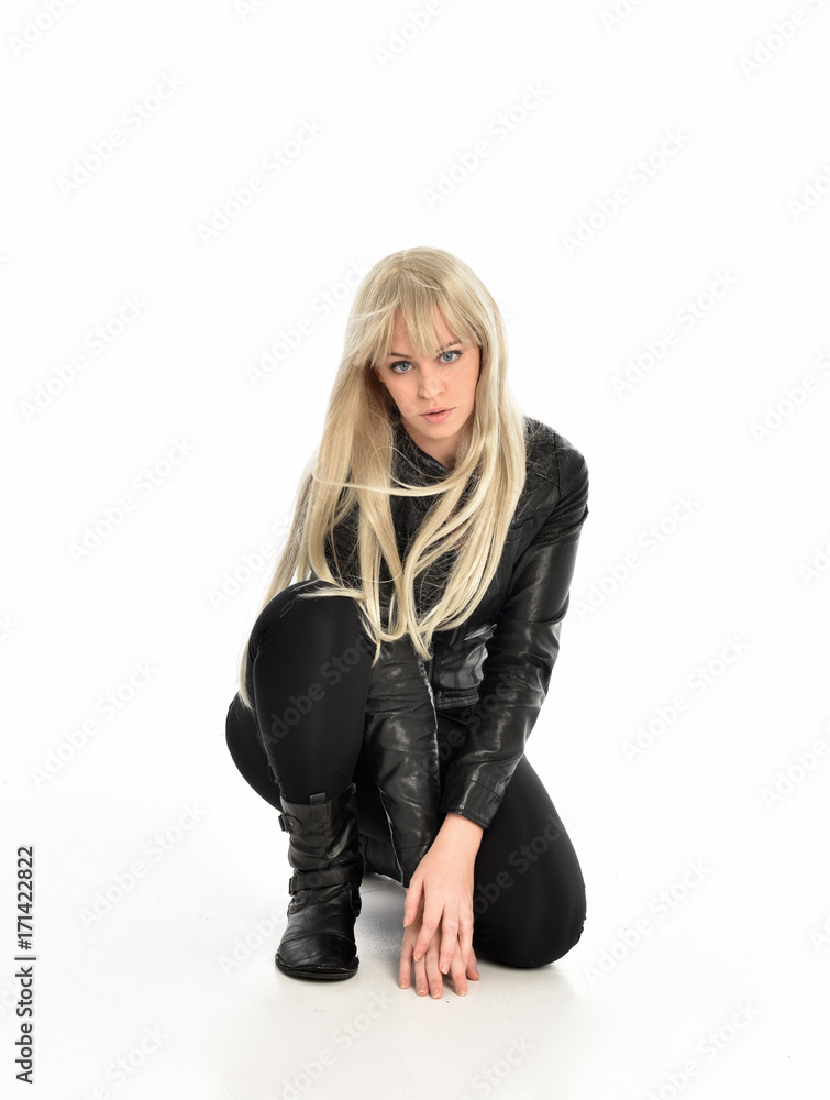 full length portrait of a blonde girl wearing black leather pose, crouching pose on white background. full length portrait of a blonde girl wearing black leather pose, crouching pose on white background.