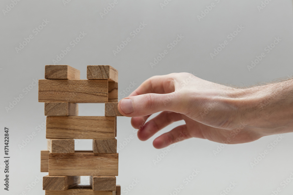 Male hand stacking wooden blocks. Business development and growth concept Male hand stacking wooden blocks. Business development and growth concept