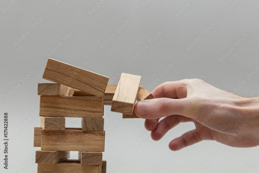 Male hand stacking wooden blocks. Business development and growth concept
