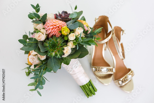 Fototapeta Naklejka Na Ścianę i Meble -  bright wedding bouquet of summer dahlias and roses with women high-heeled shoes