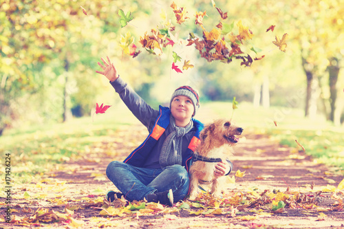 aufgeweckter Junge mit seinem Hund im Herbst