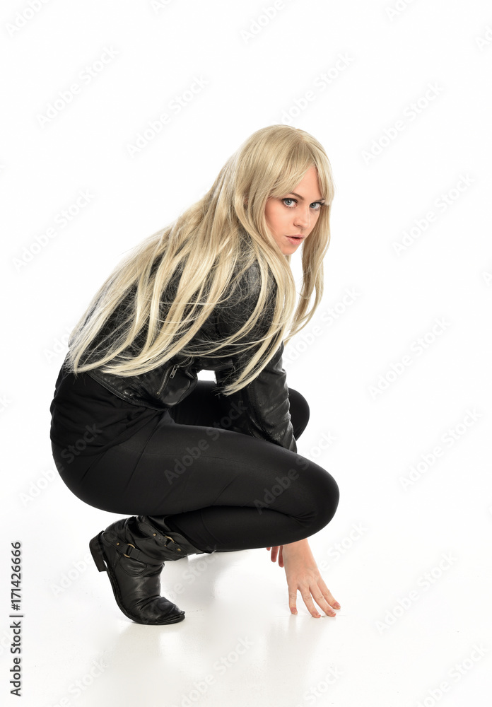 full length portrait of a blonde girl wearing black leather pose, crouching pose on white background. full length portrait of a blonde girl wearing black leather pose, crouching pose on white background.