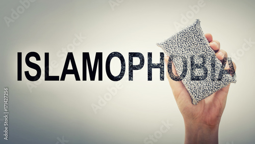 Man's hand erasing the word islamophobia