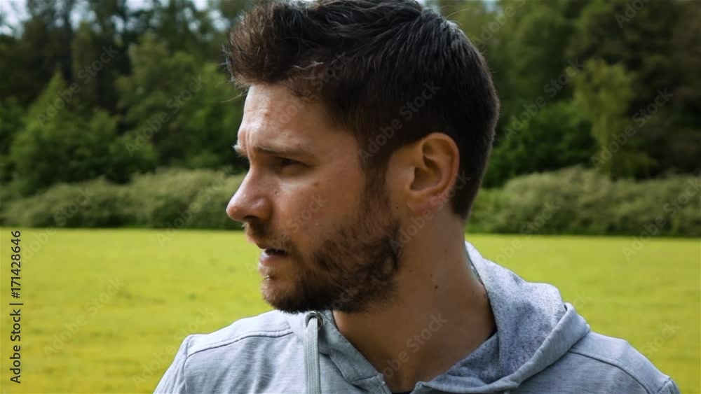 Epic shot with turning head of athlete runner in park. Sweat on his face super slow motion. Look at camera. Closeup Epic shot with turning head of athlete runner in park. Sweat on his face super slow motion. Look at camera. Closeup