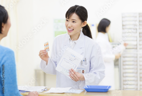 Female pharmacist talking with customer photo