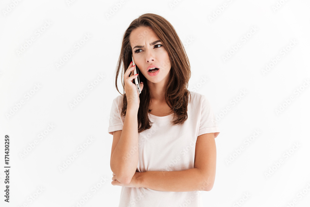 Confused brunette woman talking by the smartphone Confused brunette woman talking by the smartphone