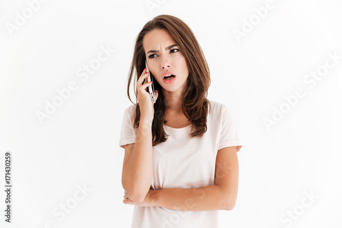 Confused brunette woman talking by the smartphone
