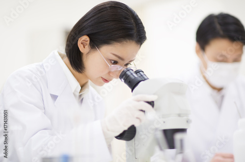 Female scientist using microscope photo