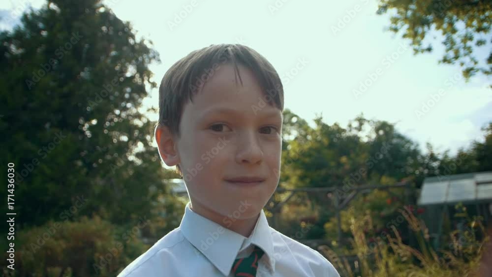 Schoolboy in Garden Sunset Extreme SlowMo 2 -a young boy is surrounded by a beautiful lens flare from the setting evening sun in summer. He smiles at the camera. Filmed at 120fps. Schoolboy in Garden Sunset Extreme SlowMo 2 -a young boy is surrounded by a beautiful lens flare from the setting evening sun in summer. He smiles at the camera. Filmed at 120fps.