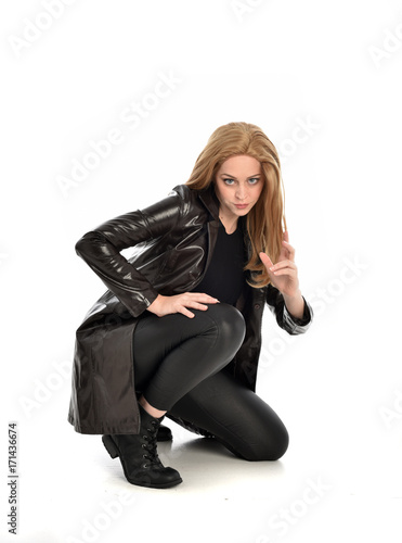 full length portrait of lady wearing leather coat and black clothing, isolated on white background.