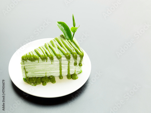 Wallpaper Mural A piece of green tea crepe cake with tea leaf topping on white plate. Torontodigital.ca