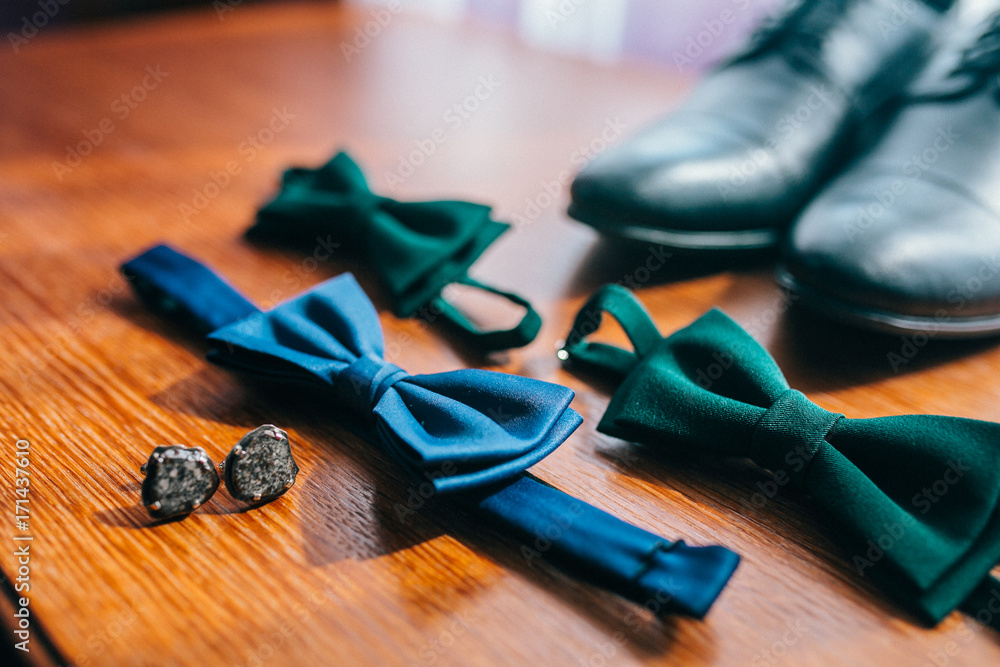 Set of trendy men's clothes and accesories. Set groom bow ties, shoes, cufflinks, on wooden background