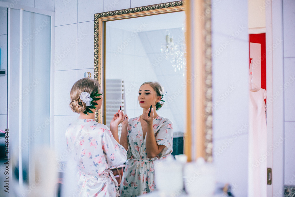 The bride is preparing for the wedding day in the morning, bride's in front of the mirror.