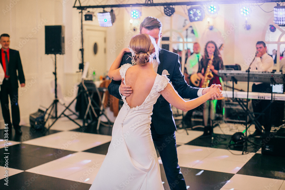 gorgeous stylish happy bride and groom performing their emotional first dance, wedding in a restaurant