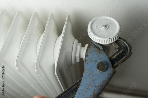 Central heating, white radiator with hand tool repairing
