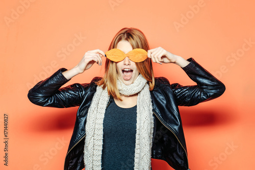 Woman with autumn leaves as glasses in leather jacket.