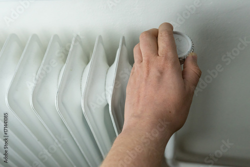 Central heating, white radiator with hand