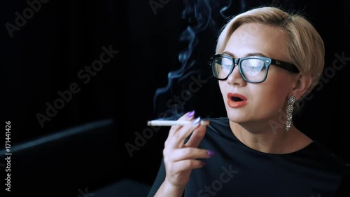 Seductive  assistant is enjoying a long-awaited 120mm after a tough day at the office. After making a long inhale the blonde-haired girl can easily forget about the stressful events of the day..