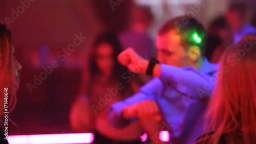 Young guys and girls are dancing in a nightclub at a New Year's party photo