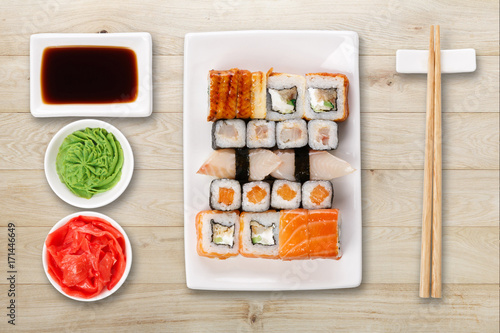 Set of sushi, maki and rolls on natural wood background