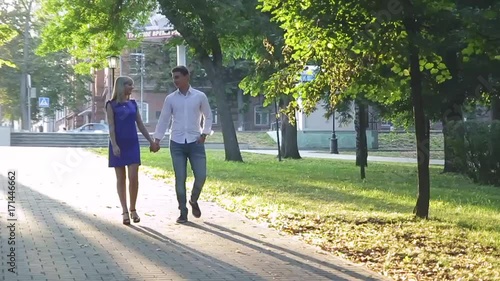 Wallpaper Mural beautiful couple in love with a woman walking in a park on a bench kissing at sunset and loving each other, a blue dress and a white shirt with jeans Torontodigital.ca