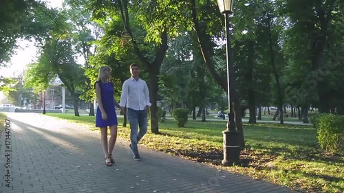 Wallpaper Mural beautiful couple in love with a woman walking in a park on a bench kissing at sunset and loving each other, a blue dress and a white shirt with jeans Torontodigital.ca