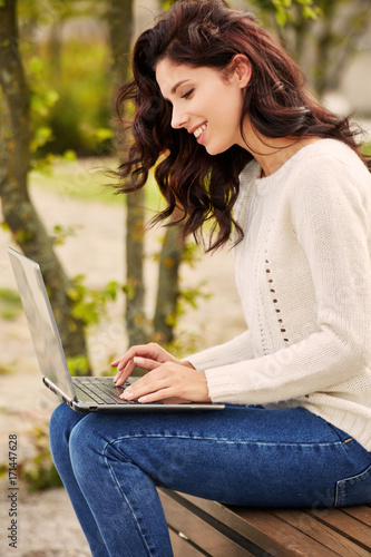 Young woman with laptop outdoors.