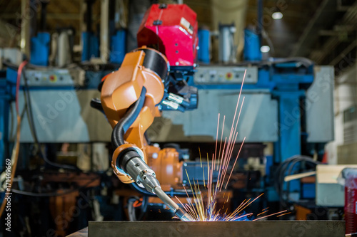 Industrial robot is welding automotive part in factory 