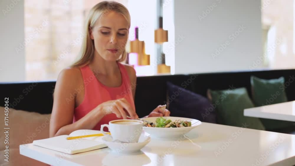 woman or reviewer eating lunch at restaurant woman or reviewer eating lunch at restaurant