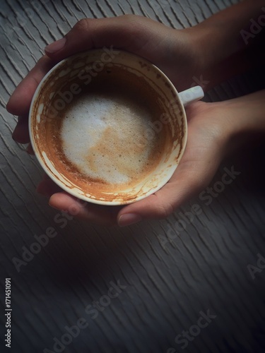A cup of cappuccino in hand