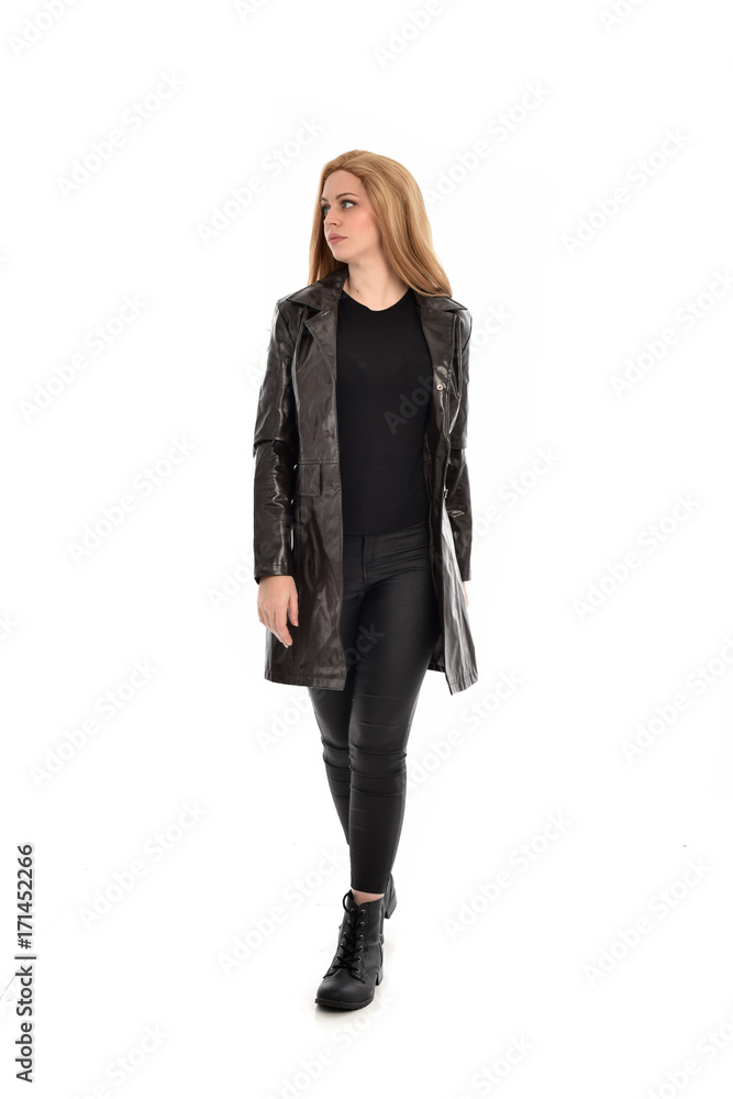 full length portrait of girl wearing black clothes with long leather jacket. standing pose on white background. full length portrait of girl wearing black clothes with long leather jacket. standing pose on white background.
