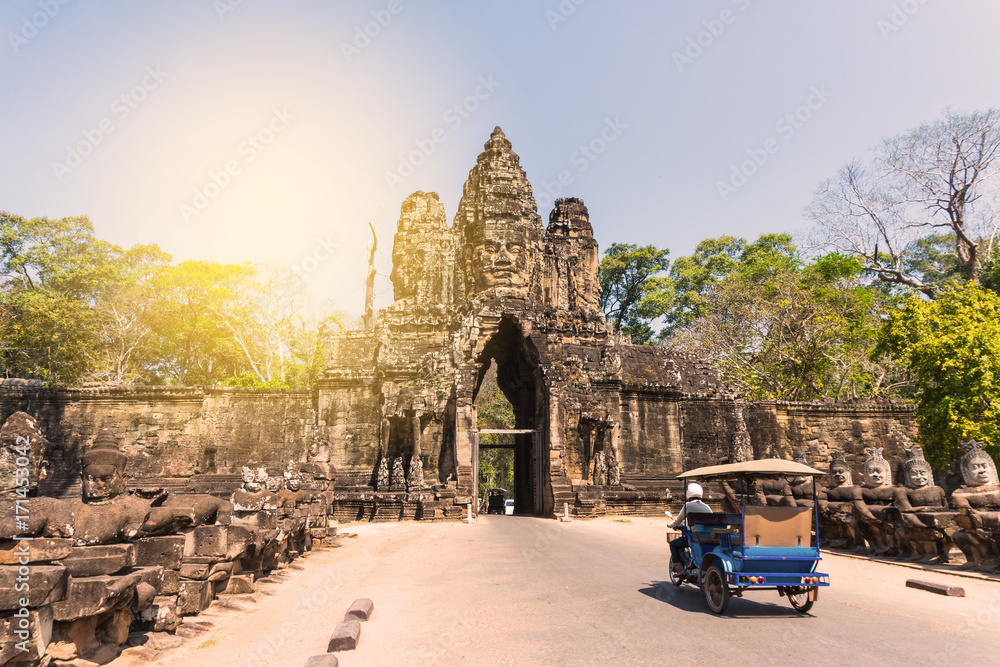 Obraz premium Tuk tuk and angkor thom gate in siem reap cambodia