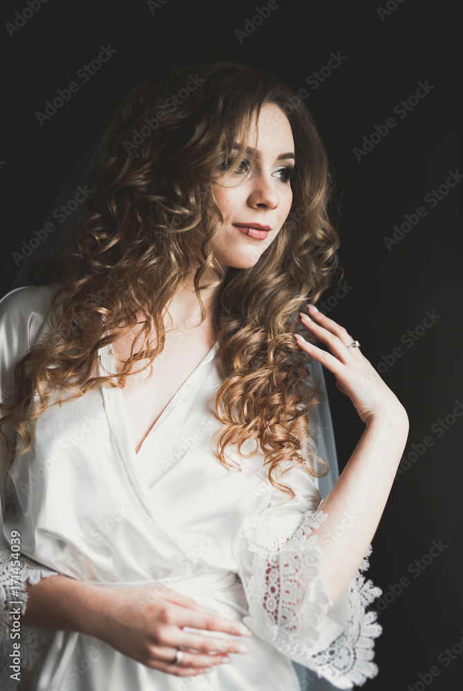 Naklejka premium Luxury bride in white dress posing while preparing for the wedding ceremony