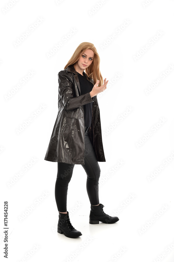 full length portrait of girl wearing black clothes with long leather jacket. standing pose on white background. full length portrait of girl wearing black clothes with long leather jacket. standing pose on white background.