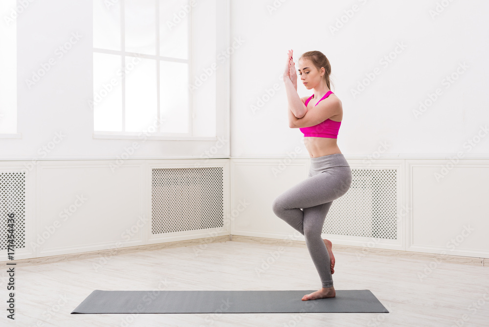 Woman training yoga in eagle pose. Woman training yoga in eagle pose.